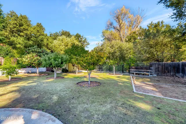 a view of swimming pool with outdoor seating and trees in the background