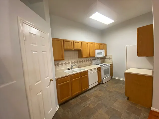 a kitchen with a sink stove and refrigerator