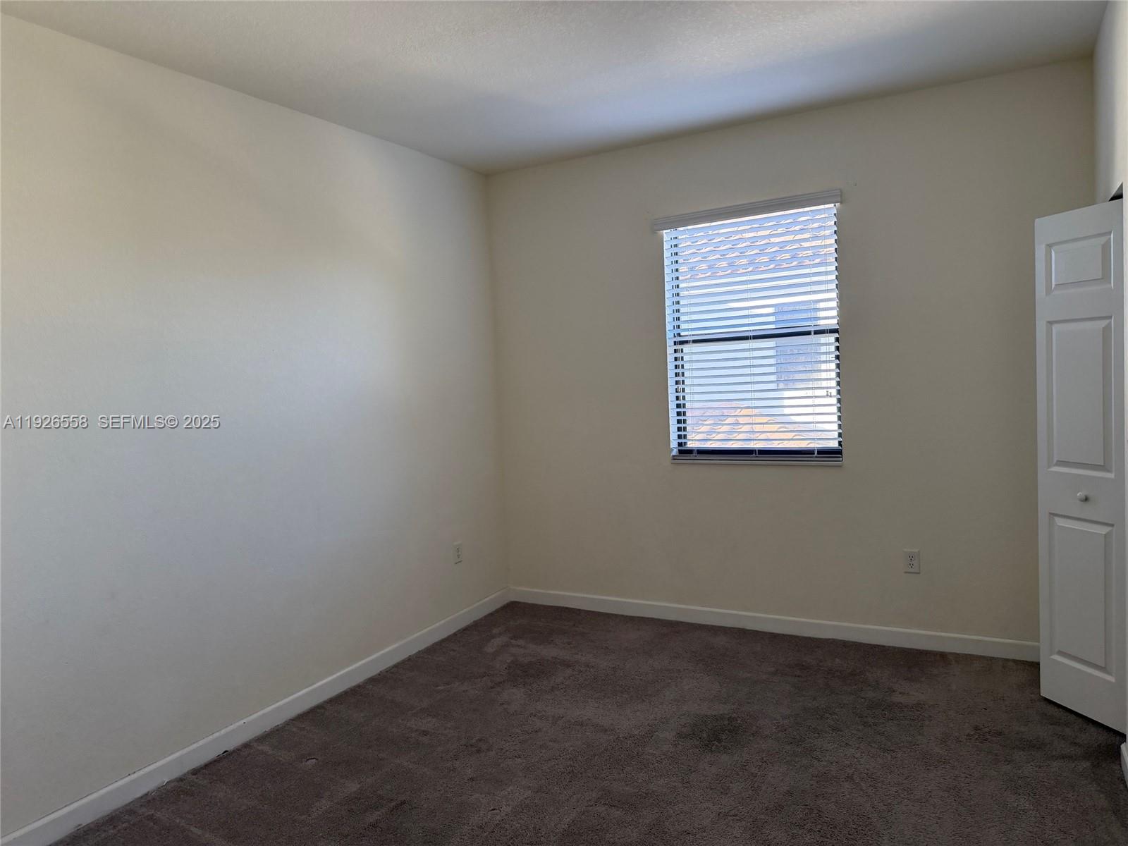 24886 Southwest 118th Avenue, Unit 24886 Homestead, FL 33032 - Photo 2 of 7 an empty room with a window