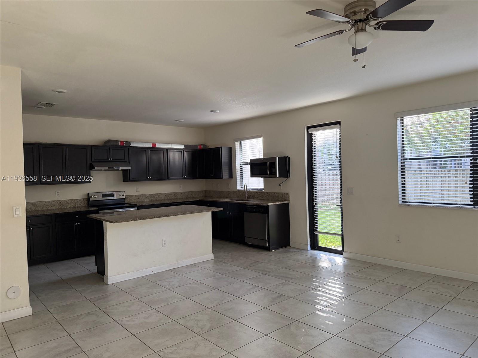 24886 Southwest 118th Avenue, Unit 24886 Homestead, FL 33032 - Photo 5 of 7 a large kitchen with cabinets and stainless steel appliances