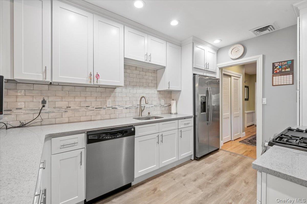 1109 Round Swamp Road Old Bethpage, NY 11804 - Photo 13 of 50 a kitchen with stainless steel appliances granite countertop a stove and a refrigerator