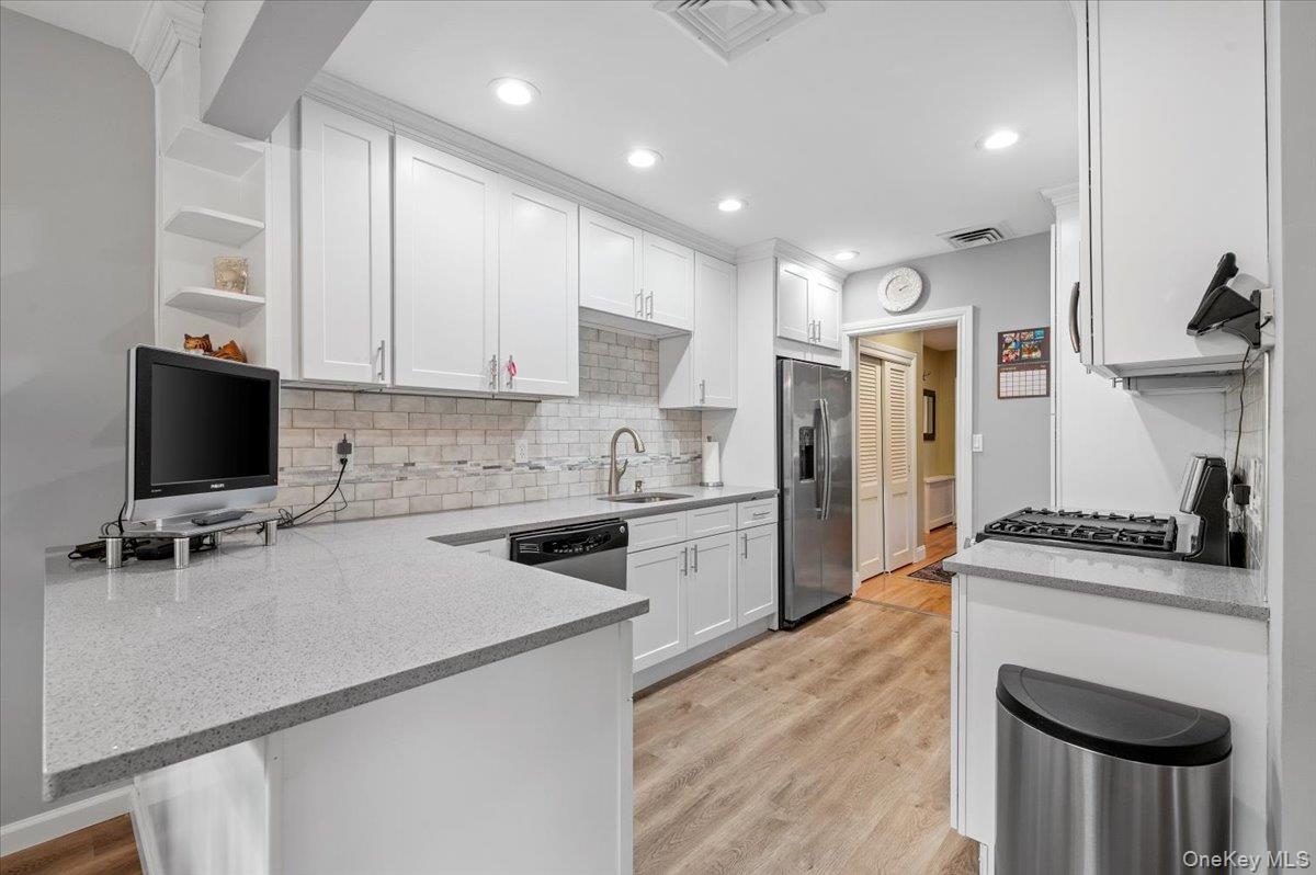 1109 Round Swamp Road Old Bethpage, NY 11804 - Photo 14 of 50 a kitchen with a stove a sink and a refrigerator