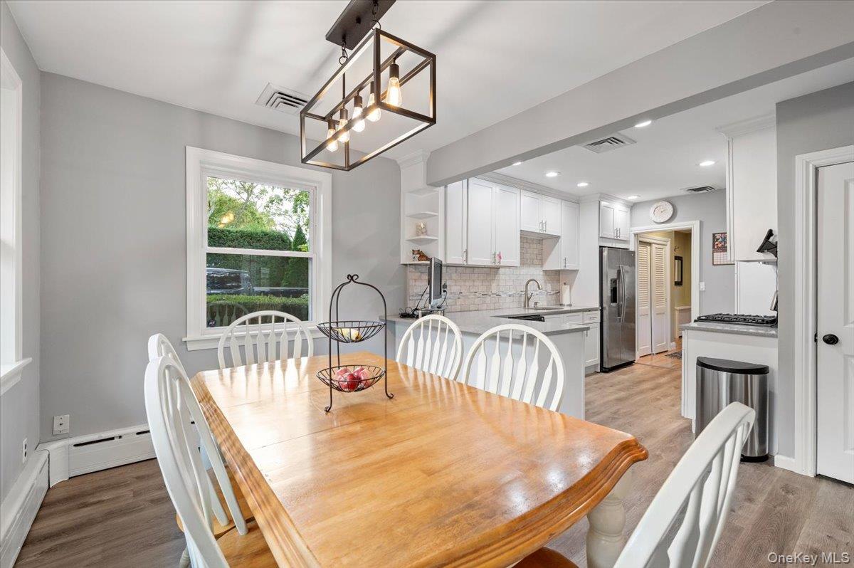 1109 Round Swamp Road Old Bethpage, NY 11804 - Photo 17 of 50 a dining room with furniture a chandelier and wooden floor