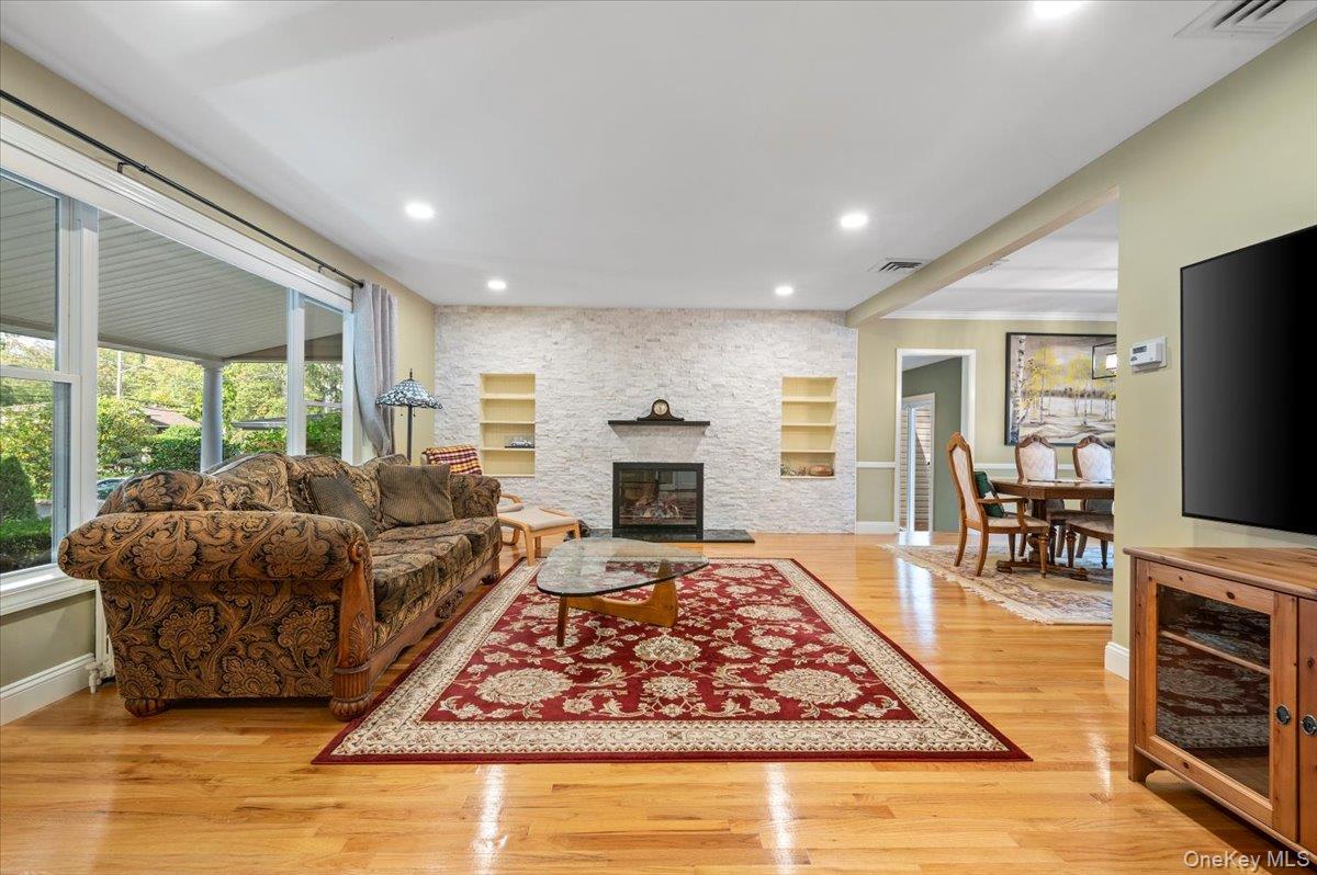 1109 Round Swamp Road Old Bethpage, NY 11804 - Photo 8 of 50 a living room with furniture flat screen tv and a fireplace