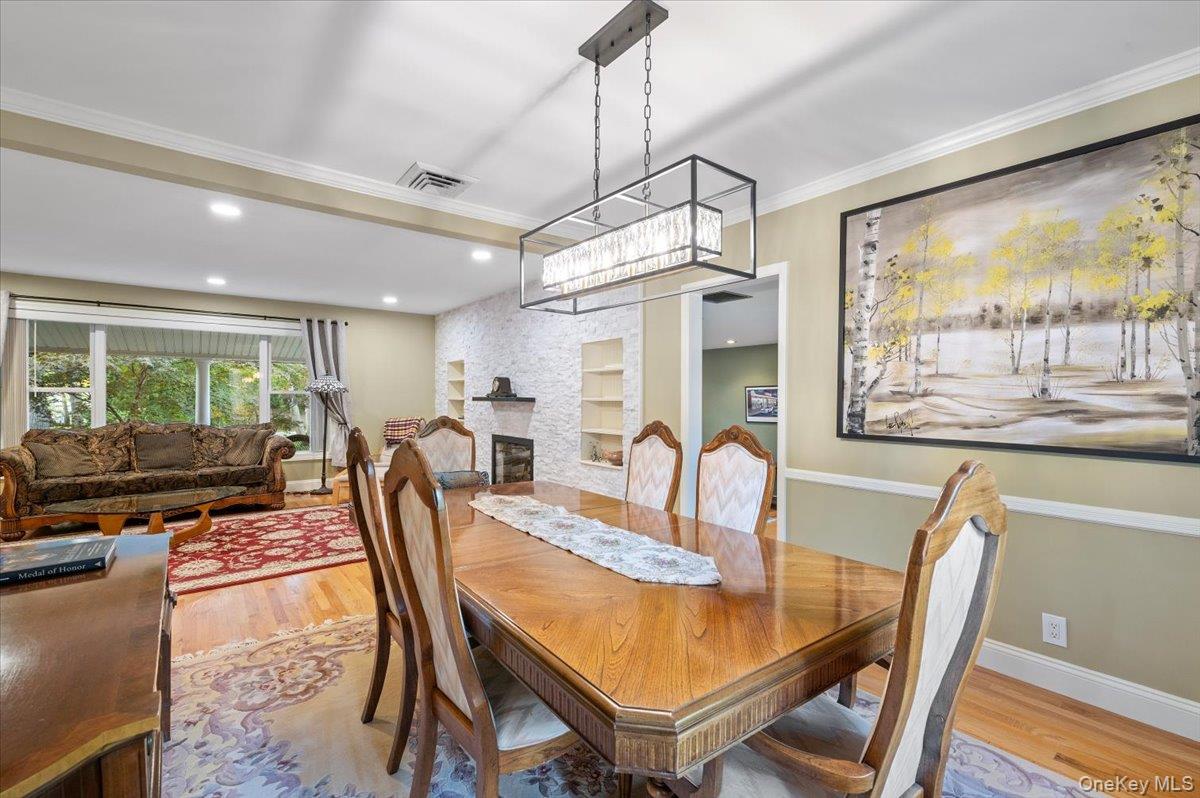 1109 Round Swamp Road Old Bethpage, NY 11804 - Photo 10 of 50 a dining room with furniture a chandelier and wooden floor