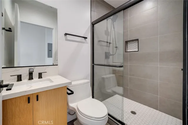 a bathroom with a sink a toilet and shower