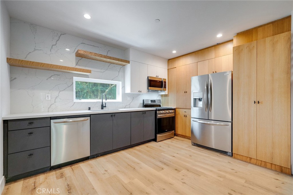 6201 La Mirada Avenue, Unit 7 Los Angeles, CA 90038 - Photo 2 of 20 a kitchen with stainless steel appliances a refrigerator sink and cabinets