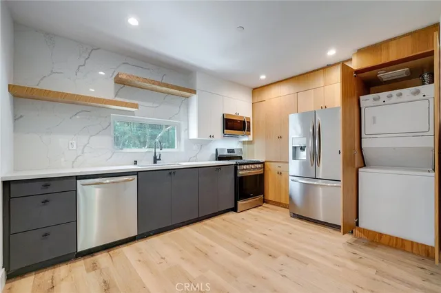 a kitchen with a refrigerator a sink a stove a microwave and wooden floor