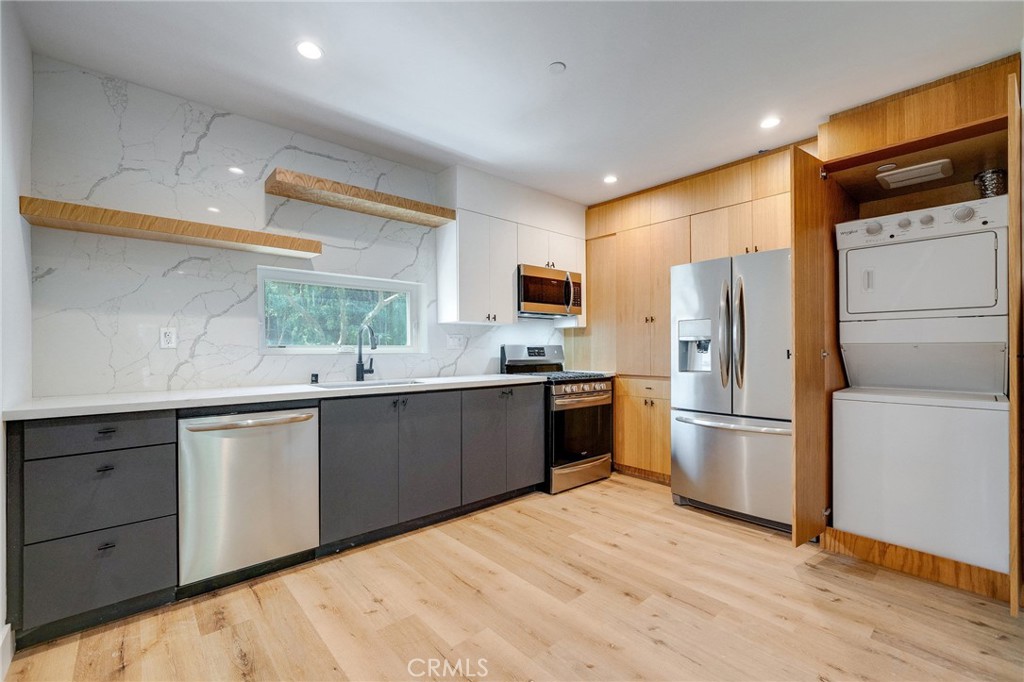 6201 La Mirada Avenue, Unit 7 Los Angeles, CA 90038 - Photo 3 of 20 a kitchen with a refrigerator a sink a stove a microwave and wooden floor
