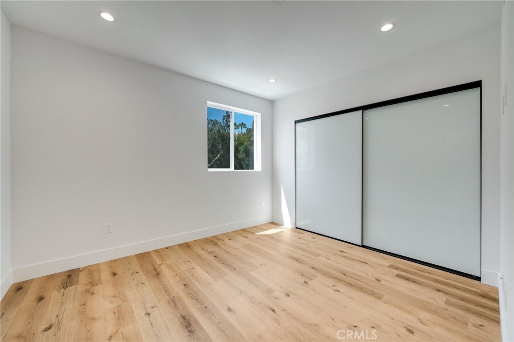 6201 La Mirada Avenue, Unit 7 Los Angeles, CA 90038 - Photo 6 of 20 a view of an empty room with wooden floor and a window