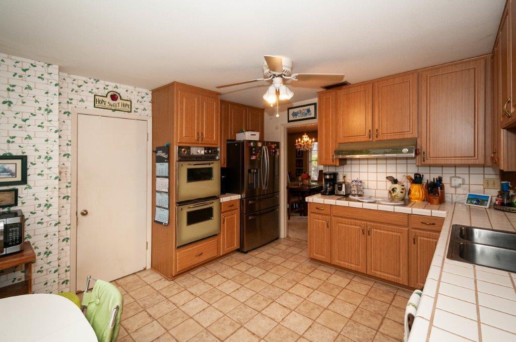 90 Country Club Road Shalimar, FL 32579 - Photo 12 of 41 a kitchen with stainless steel appliances a stove top oven a sink a refrigerator and cabinets