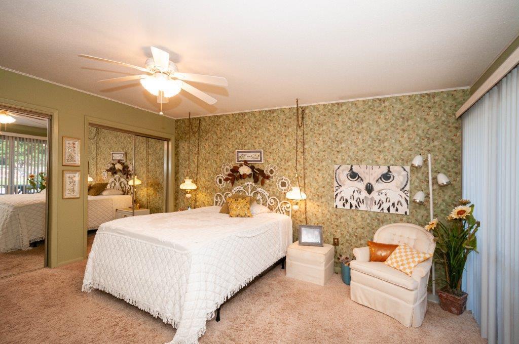 90 Country Club Road Shalimar, FL 32579 - Photo 24 of 41 a bedroom with a large bed and a chandelier