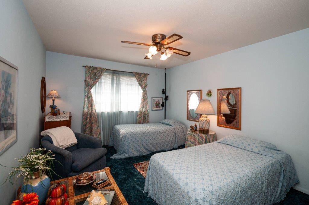 90 Country Club Road Shalimar, FL 32579 - Photo 27 of 41 a bedroom with two beds and a chandelier