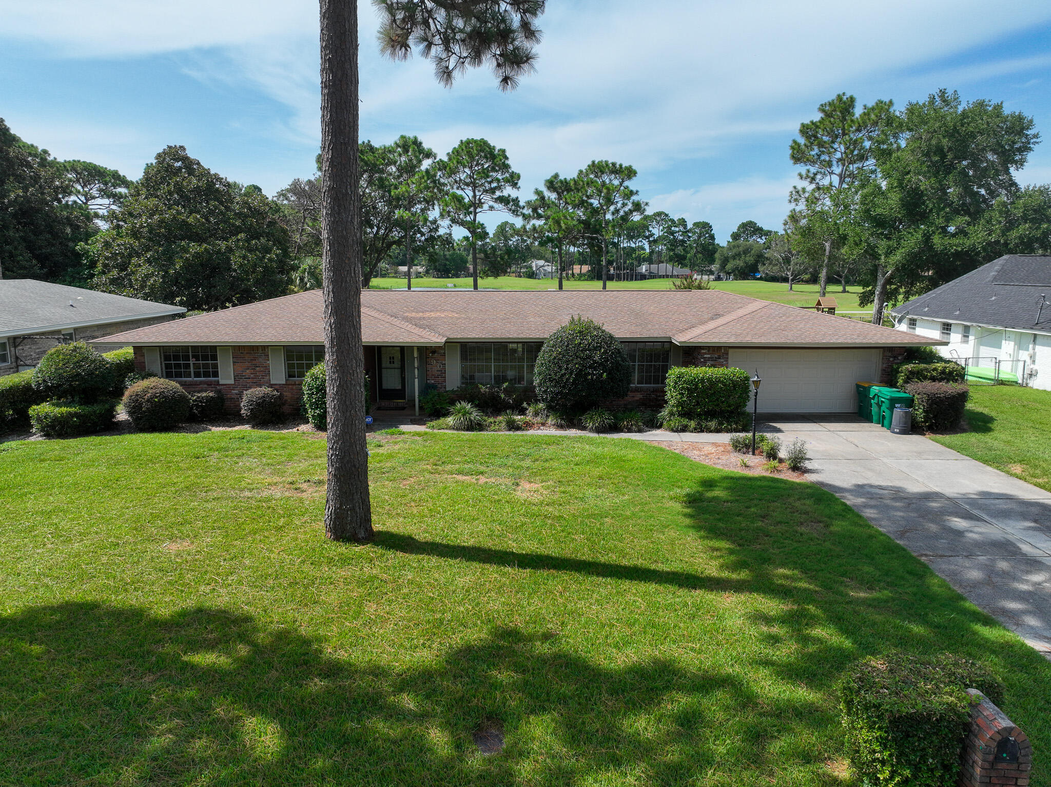 90 Country Club Road Shalimar, FL 32579 - Photo 34 of 41 a view of a house with a big yard potted plants and palm trees