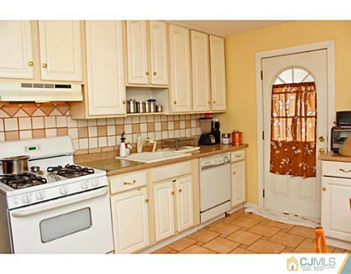 166 Winthrop Road Edison, NJ 08817 - Photo 12 of 17 a kitchen with granite countertop a stove a sink and white cabinets
