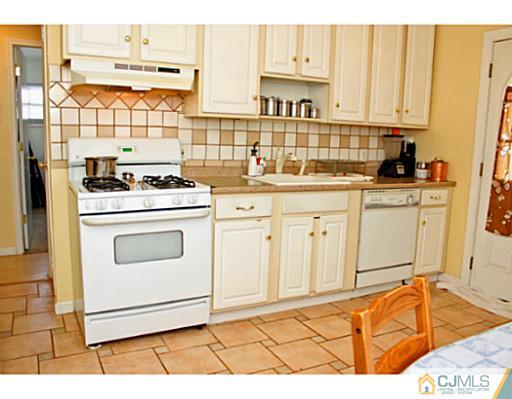 166 Winthrop Road Edison, NJ 08817 - Photo 10 of 17 a kitchen with granite countertop white cabinets and white appliances