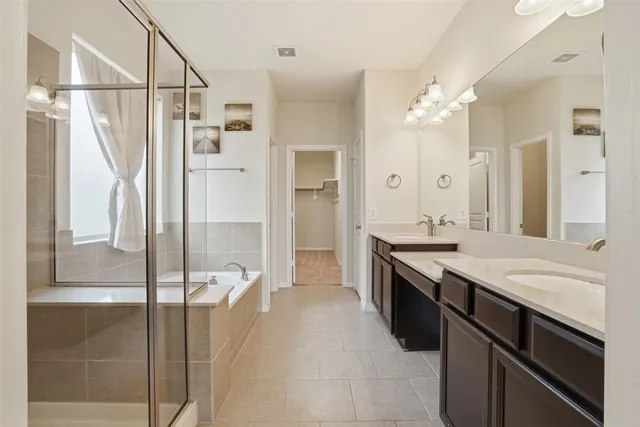 a spacious bathroom with a granite countertop sink a mirror a shower and a bathtub