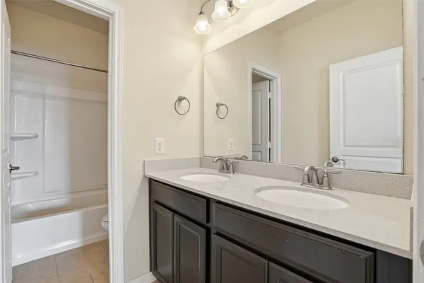 a bedroom with a bed a chandelier and a dresser