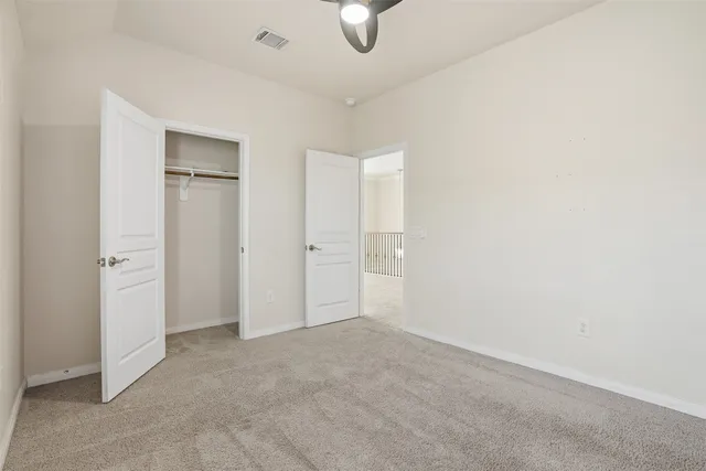 an empty room with closet and windows