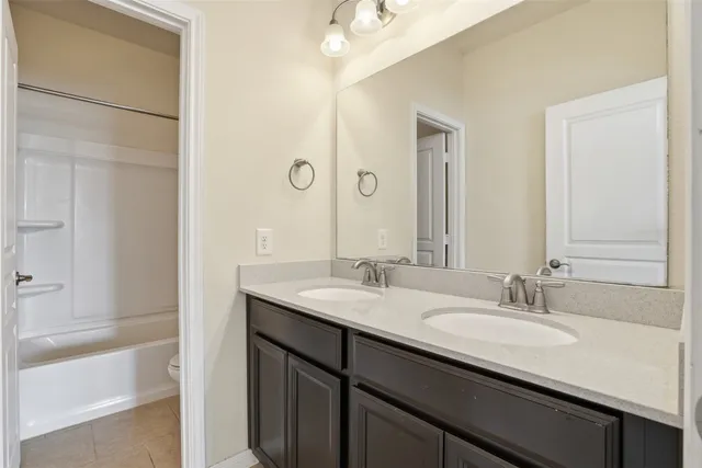 a bathroom with a granite countertop sink mirror and a bathtub