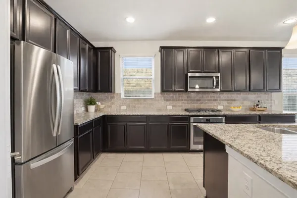 a large kitchen with granite countertop stainless steel appliances and a sink
