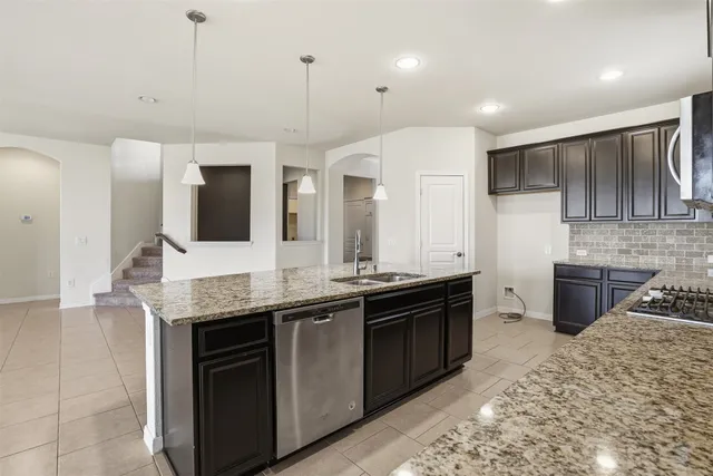 a kitchen with stainless steel appliances granite countertop a sink and a stove