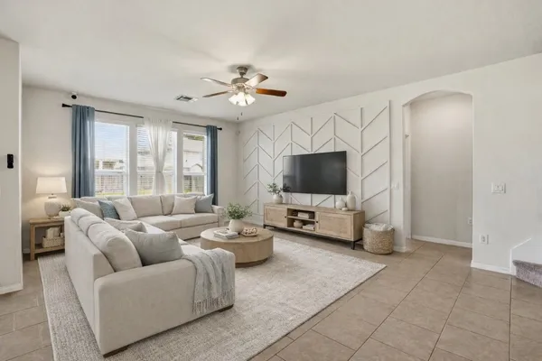 a living room with furniture a flat screen tv and a large window