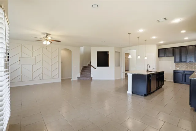 a large white kitchen with a large island in the center and a sink