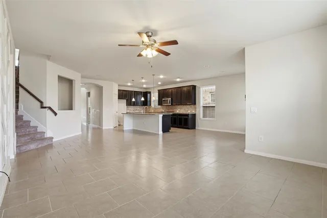 a view of a kitchen with a sink cabinet a microwave and refrigerator
