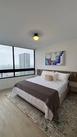 a bedroom with a bed and a painting on the wall