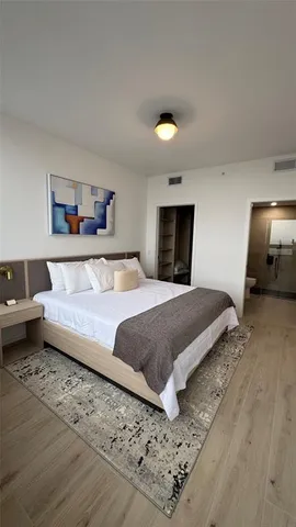 a bedroom with a large bed and a wooden floor