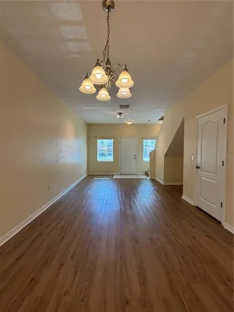 a view of a room with wooden floor and chandelier
