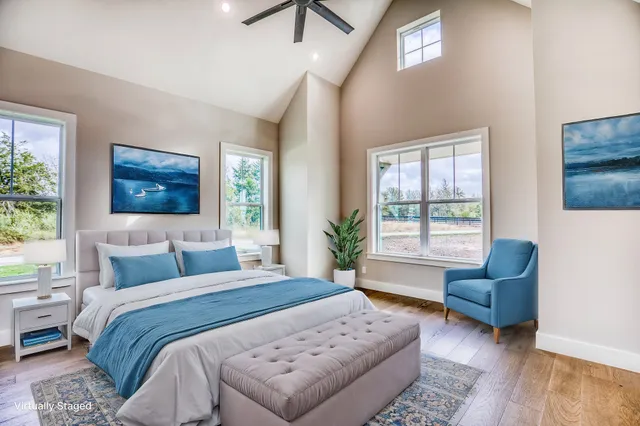 a bedroom with a bed couches and a flat tv screen