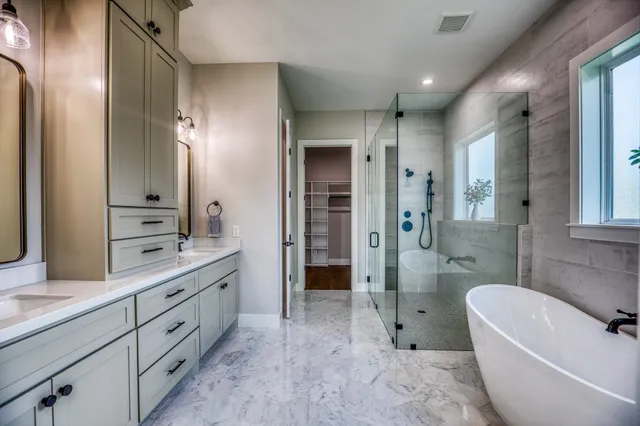 a spacious bathroom with a double vanity sink a large mirror and a bathtub