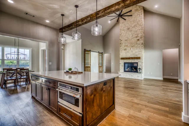 a kitchen with stainless steel appliances granite countertop a stove and a wooden floors