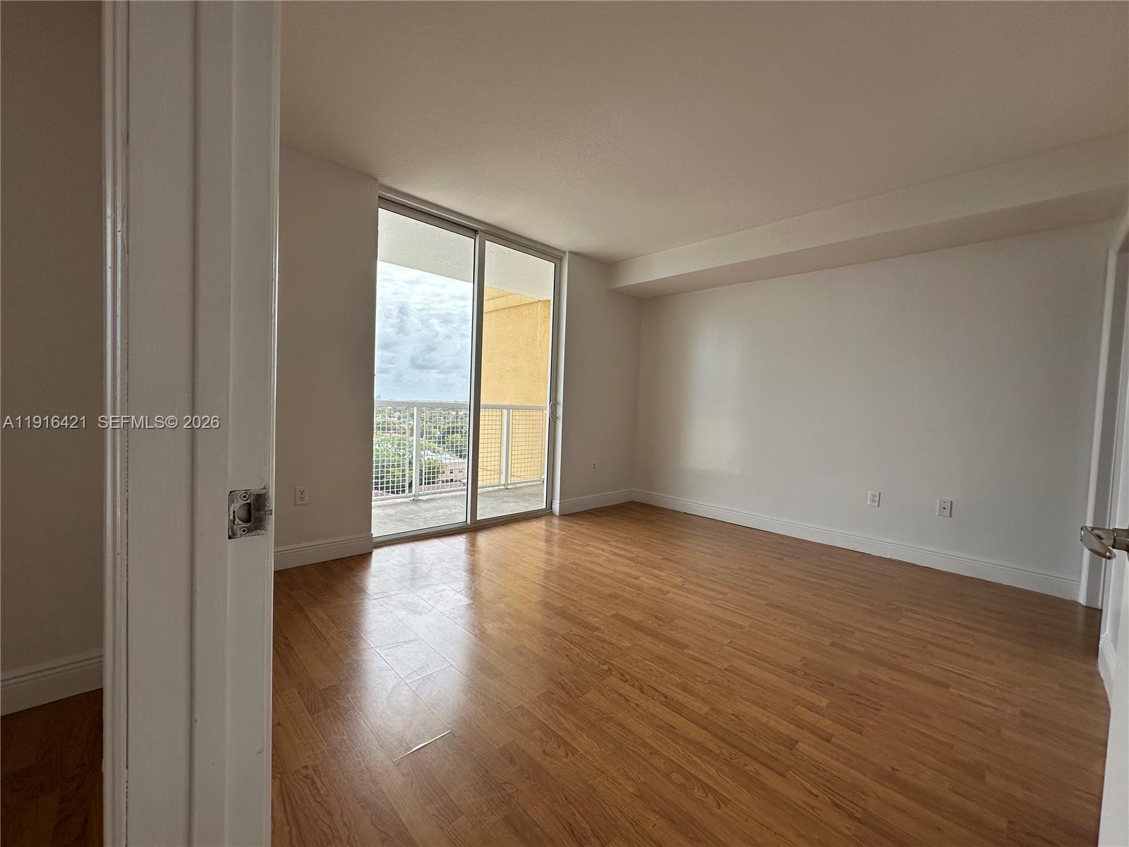 900 Southwest 8th Street, Unit 1010 Miami, FL 33130 - Photo 18 of 27 a view of an empty room with wooden floor and a window
