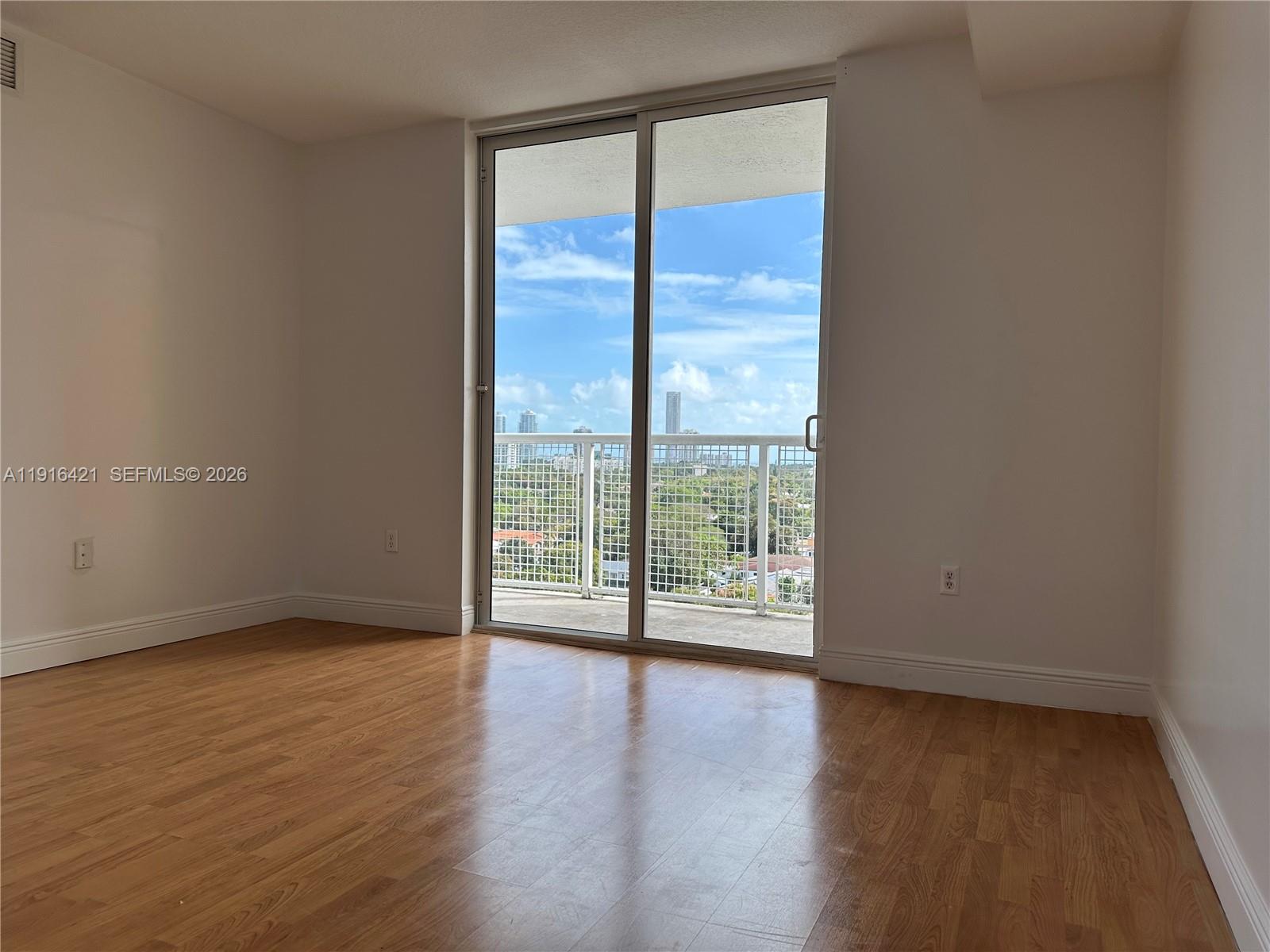 900 Southwest 8th Street, Unit 1010 Miami, FL 33130 - Photo 19 of 27 a view of an empty room with wooden floor and a window
