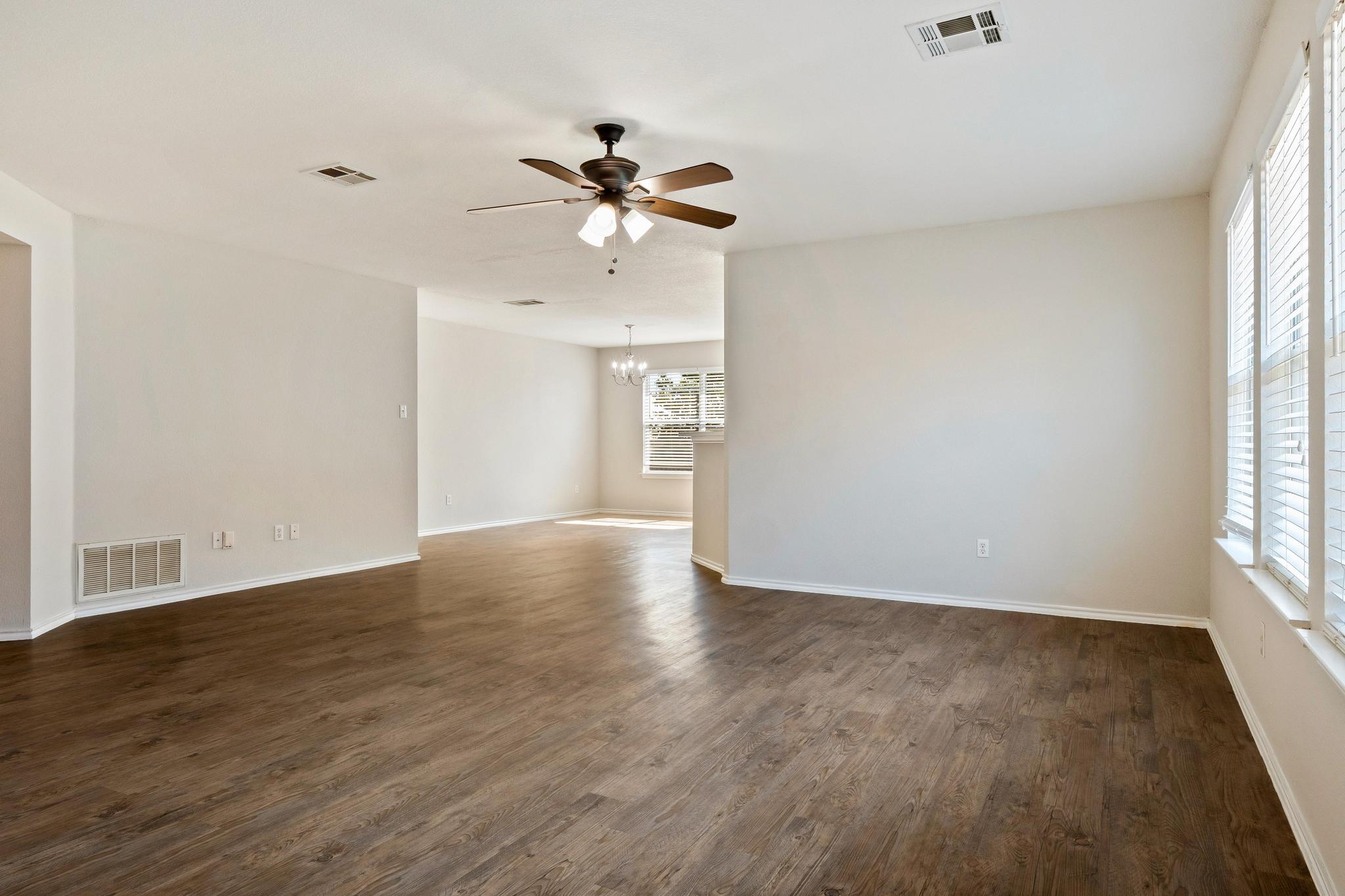162 Brandons Way Buda, TX 78610 - Photo 20 of 36 a view of an empty room with a window and wooden floor