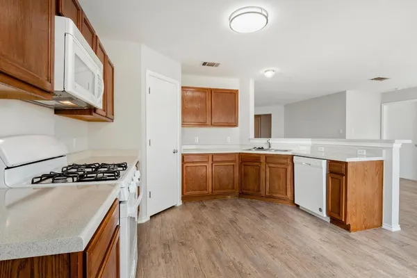 a kitchen with granite countertop a stove top oven sink and cabinets