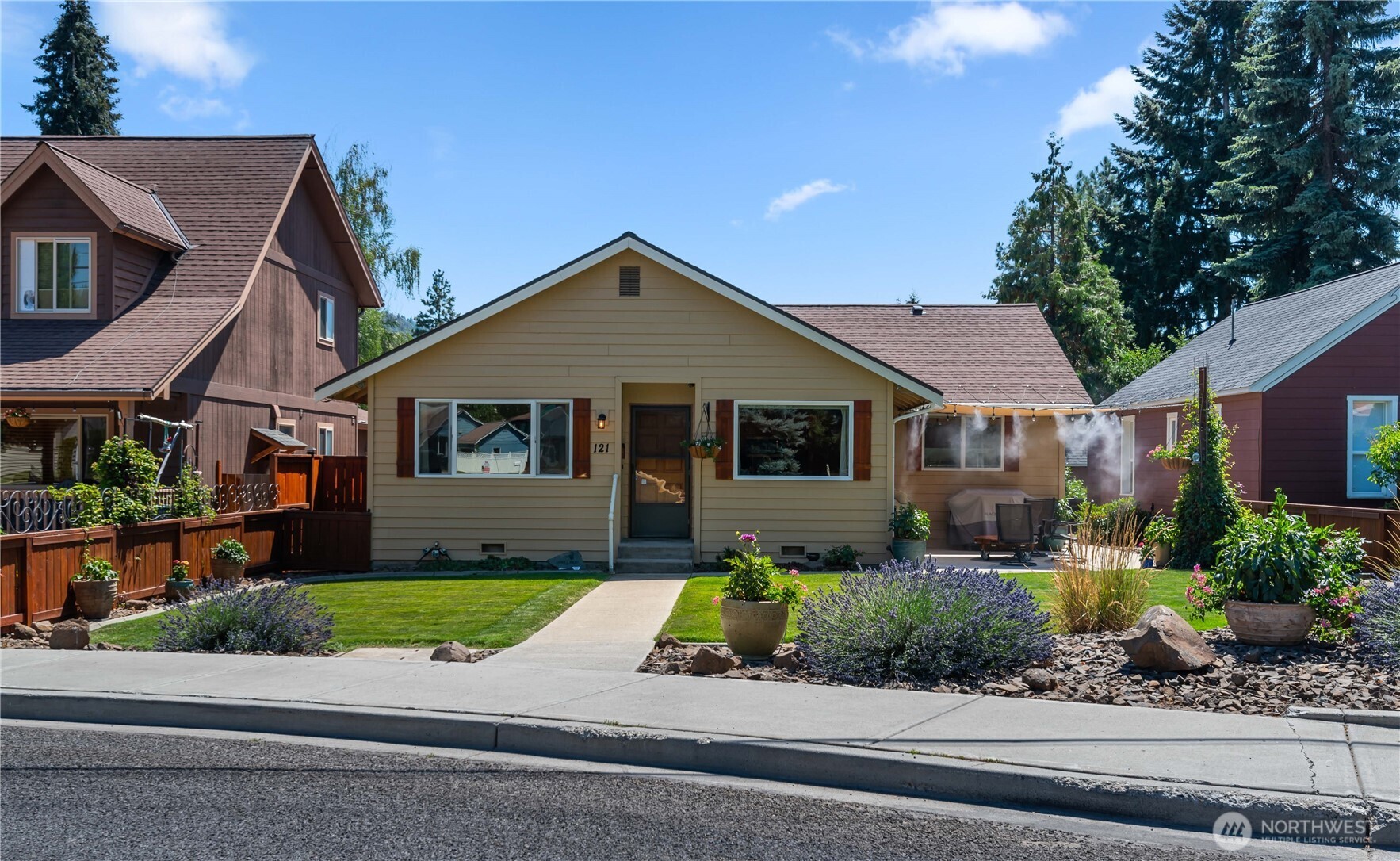 a front view of a house with a yard and potted plants