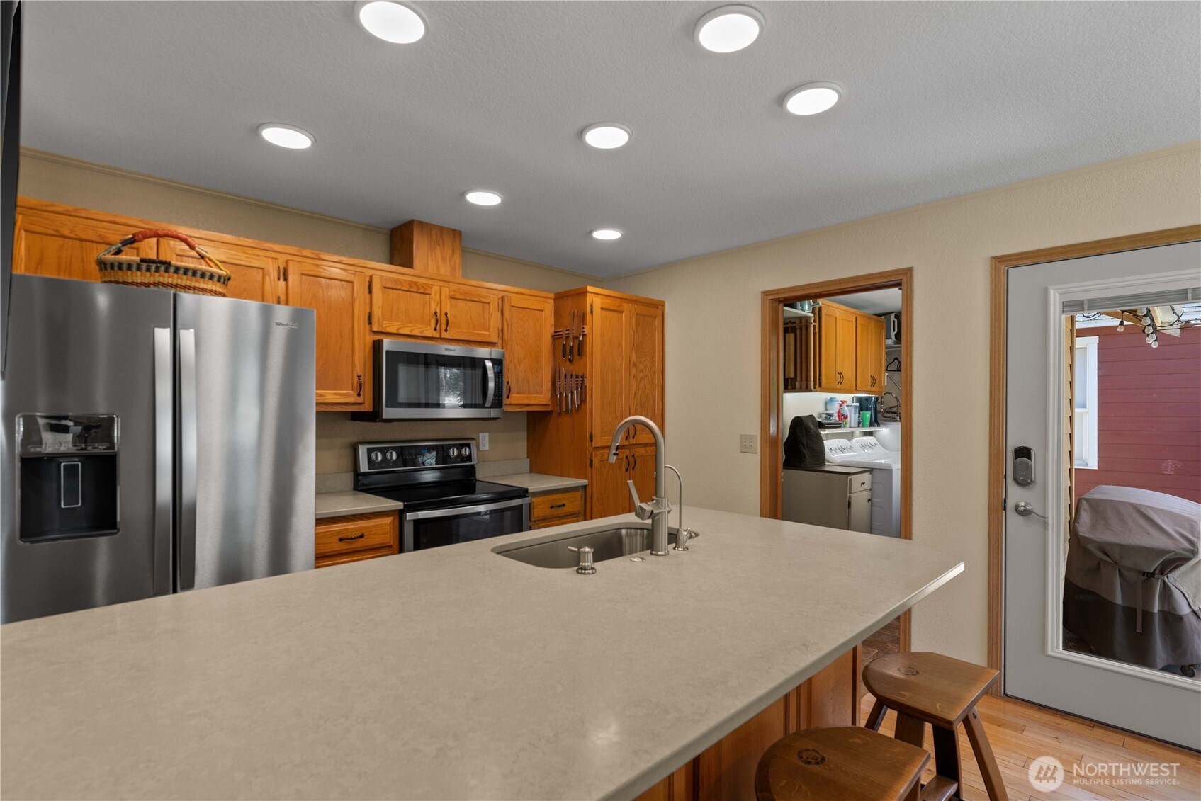 121 Benton Street Leavenworth, WA 98826 - Photo 12 of 37 a kitchen with stainless steel appliances granite countertop a refrigerator oven a sink dishwasher a dining table and chairs with wooden floor