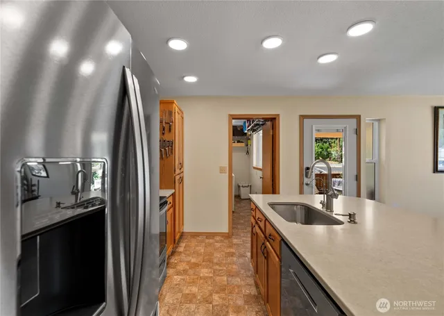 a kitchen with stainless steel appliances granite countertop a sink refrigerator and stove