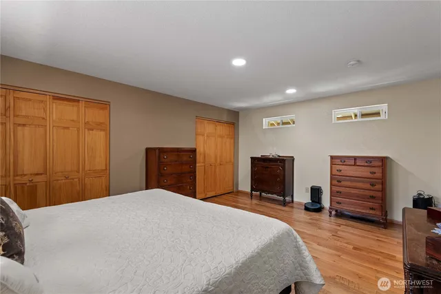 a bedroom with a large bed and a flat tv screen