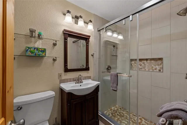 a bathroom with a sink a toilet and shower