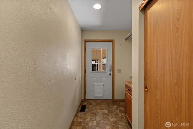 a view of a hallway with wooden floor and a bathroom
