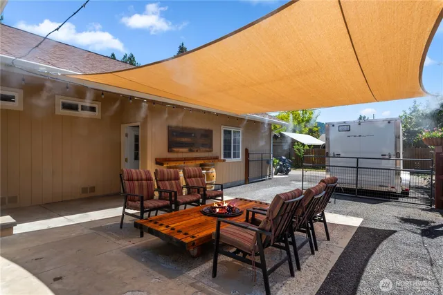 a view of a patio with a table and chairs under an umbrella