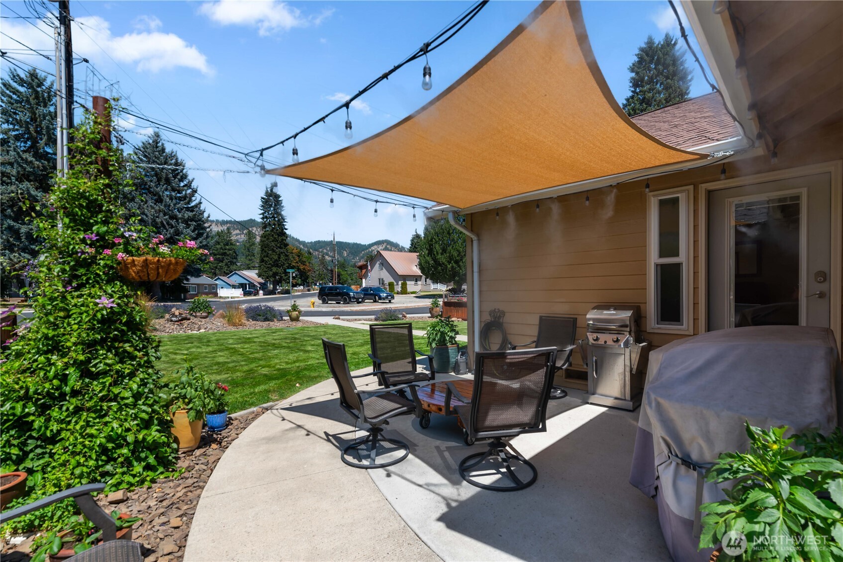 121 Benton Street Leavenworth, WA 98826 - Photo 27 of 37 a view of a patio with table and chairs potted plants and a palm tree