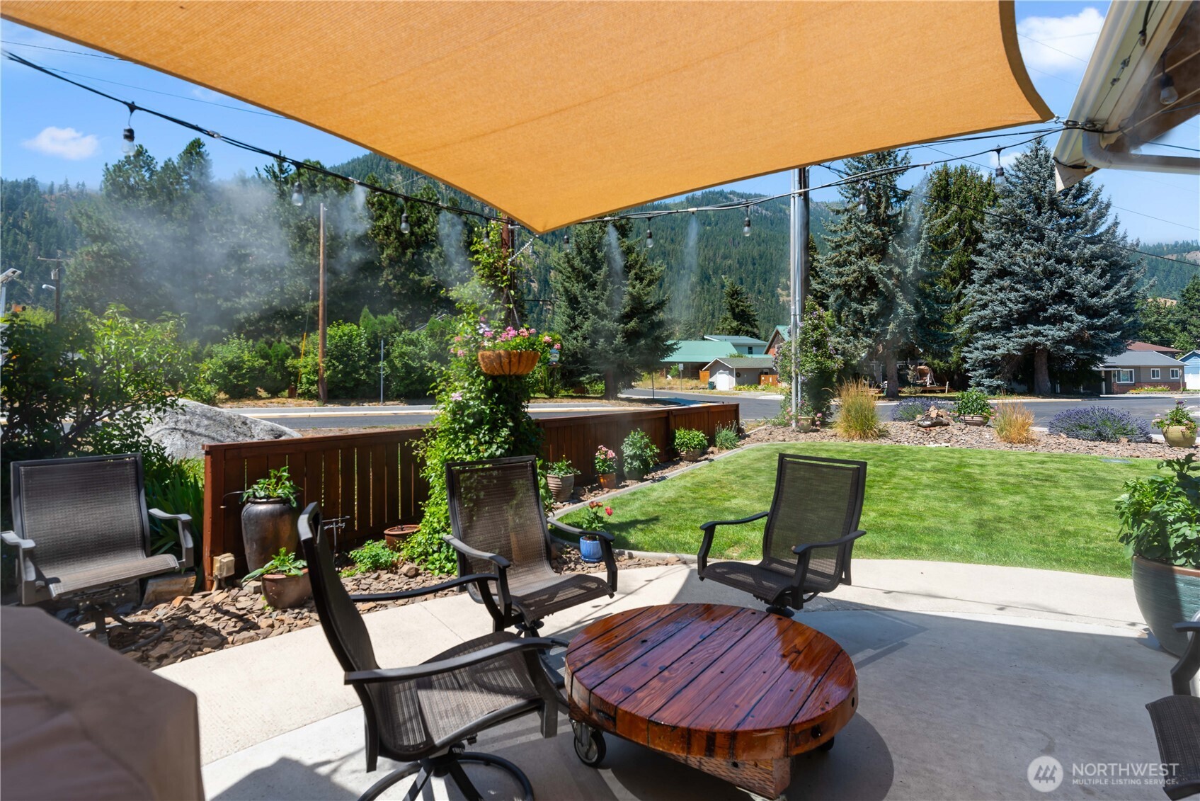 121 Benton Street Leavenworth, WA 98826 - Photo 28 of 37 a view of a patio with table and chairs potted plants with wooden fence