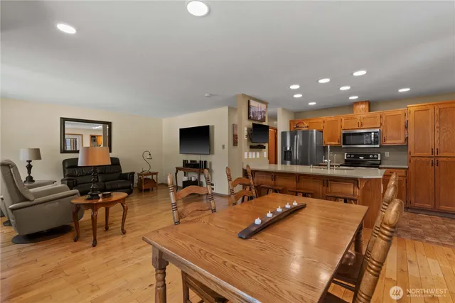 a living room with stainless steel appliances furniture stove and kitchen view