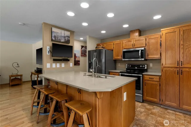 a kitchen with stainless steel appliances a stove refrigerator sink and microwave